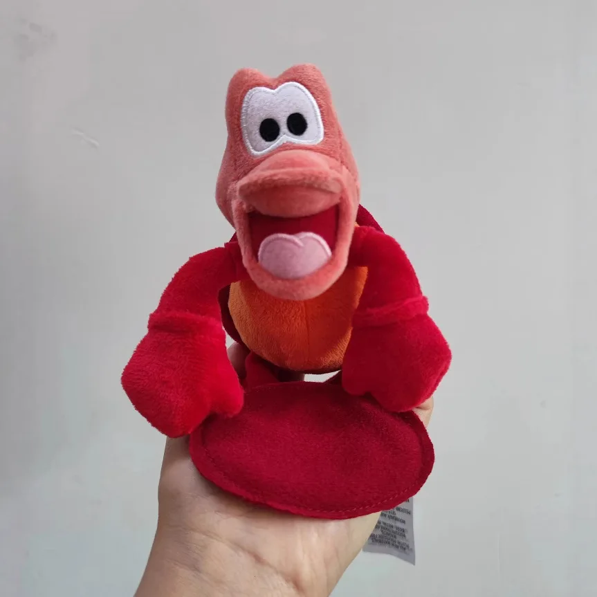 Peluche Sebastião - A Pequena Sereia 18cm - Bonecos de Peluche da Pequena Sereia Disney Descobre o divertido Peluche Sebastião - A Pequena Sereia 18cm! Um peluche Disney macio e adorável, perfeito para fãs da Ariel e das aventuras no fundo do mar. Ideal para brincar, decorar ou oferecer.