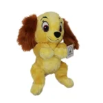 Descubra o Peluche Dama - A Dama e o Vagabundo 25cm. Um peluche Disney macio e encantador, perfeito para crianças, fãs dos clássicos e colecionadores.
